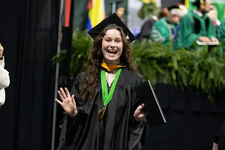 a student with a cap gown and medal on at commencement